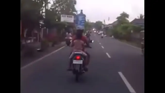 Greget! Ibu di Bali Naik Motor Sambil Bawa Air Galon di Kepala!
