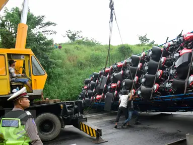 Truk pengangkut puluhan sepeda motor sport  terguling dengan posisi melintang di Ruas Tol  KM 10 Kota Semarang, Jawa Tengah, Senin (6/3). (Liputan6.com/Gholib)