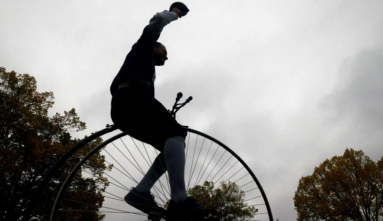 Seorang penggemar sepeda mengenakan kostum sejarah sambil mengendarai Penny Farthing atau dikenal sebagai sepeda roda tinggi selama kompetisi tradisonal 'One Mile Race' di Praha, Republik Ceko pada 3 November 2018. (Photo by Michal CIZEK / AFP)