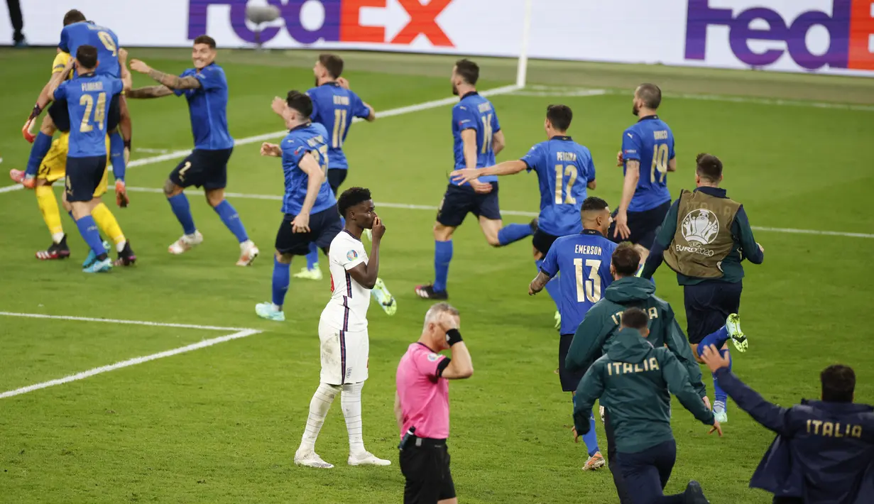 Reaksi pemain Inggris Bukayo Saka usai gagal melepaskan tembakan ke gawang Italia saat adu penalti pada final Euro 2020 di Stadion Wembley, London, Inggris, Minggu (11/7/2021). Italia menang 3-2 lewat adu penalti usai bermain imbang 1-1. (John Sibley/Pool Photo via AP)