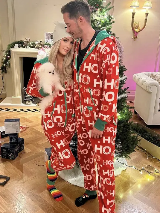 Merayakan natal bersama, keduanya kompak mengenakan jumpsuit merah dengan tulisan Hoho. (@parishilton)