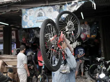 Warga memikul sepeda yang baru dibeli di sebuah toko di Kramat Jati, Jakarta, Minggu (21/6/2020). Dalam sebulan terakhir, penjualan sepeda di Ibu Kota meningkat hingga 50 persen seiring minat dan tren warga yang melonjak menggunakan transportasi gowes itu di masa pandemi. (merdeka.com/Iqbal Nugroho)