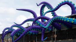 Sebuah patung karet berjudul "Sea Monsters HERE" menghiasi gudang berkarat Building 61 di Navy Yard di Philadelphia, Selasa (9/10). Instalasi buatan seniman Inggris Filthy Luker dan Pedro Estrellas ini ditampilkan hingga 16 November 2018. (AP/Matt Rourke)