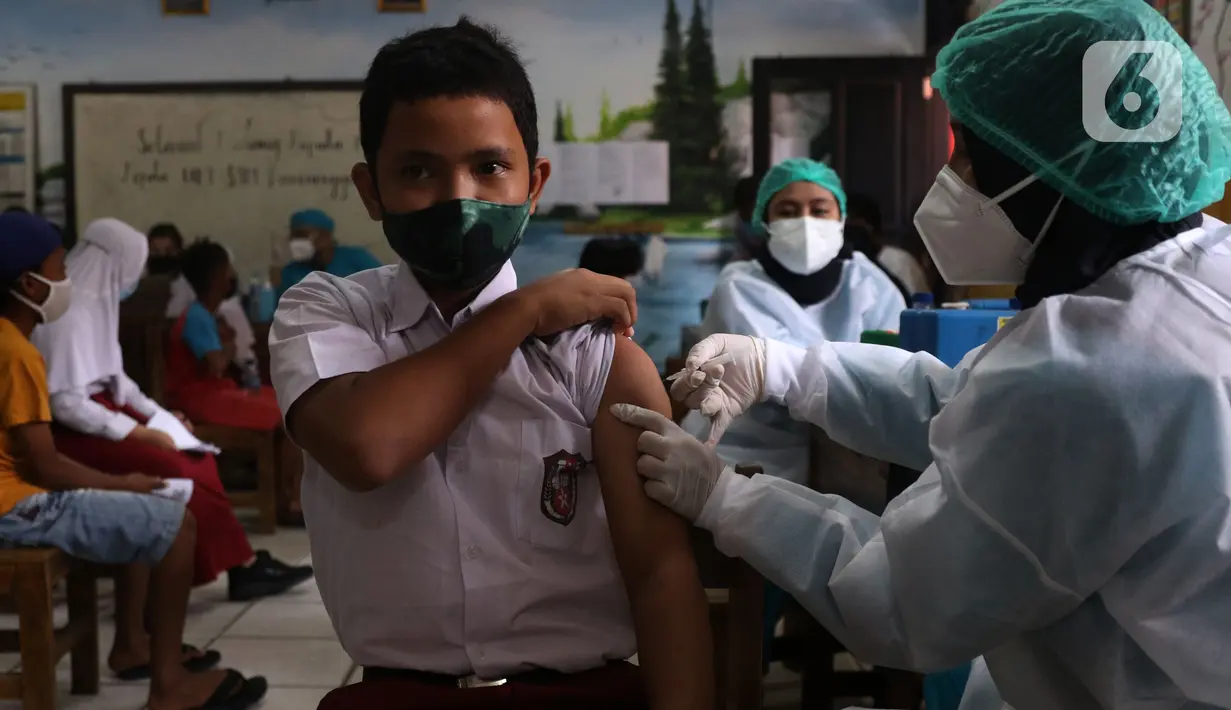 Petugas menyuntikan vaksin COVID-19 Pfizer kepada seorang siswa di SDN Panunggangan 5, Pinang, Kota Tangerang, Selasa (19/10/2021).  Pelaksanaan vaksinasi untuk pelajar usia 12 tahun ini dilakukan dalam rangka persiapan pelaksanaan pembelajaran tatap muka (PTM). (Liputan6.com/Angga Yuniar)