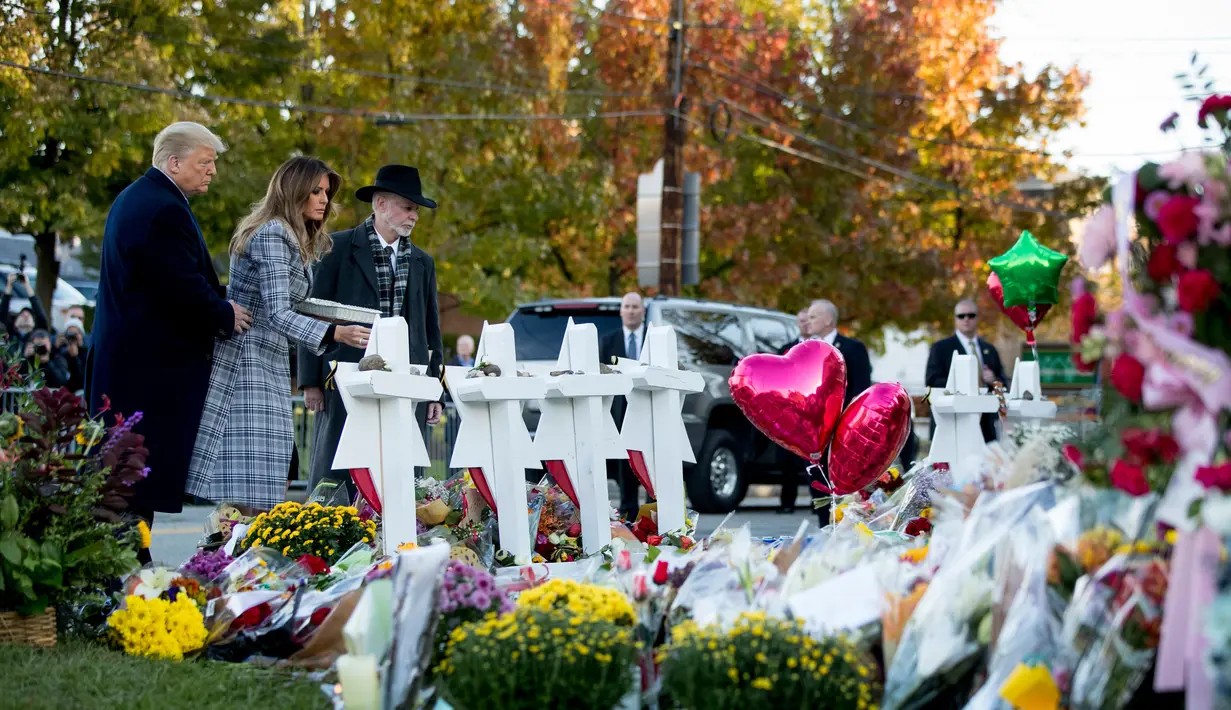 Melania Trump didampingi Presiden Donald Trump dan Rabbi Jeffrey Myers meletakkan bunga di monumen peringatan penembakan maut di sinagog Tree of Life, Kota Pittsburgh, Pennsylvania, AS, Selasa (30/10). (AP Photo/Andrew Harnik)
