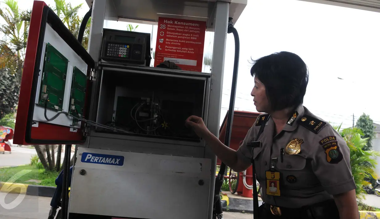 Seorang polwan mengamati pompa bensin saat gelar perkara  di SPBU kawasan Rempoa, Ciputat, Tangsel, Senin (6/6). SPBU tersebut disegel petugas karena ditemukan praktik pengurangan literan (takaran) pengisian bahan bakar. (Liputan6.com/Helmi Afandi)