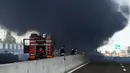 Petugas pemadam kebakaran berada di lokasi ledakan truk tangki yang membawa bahan mudah terbakar di jalan raya dekat kota Bologna, Italia, Senin (6/8). Kuatnya ledakan bahkan sampai menyebabkan jalan layang rusak. (AFP/Gianni SCHICCHI)