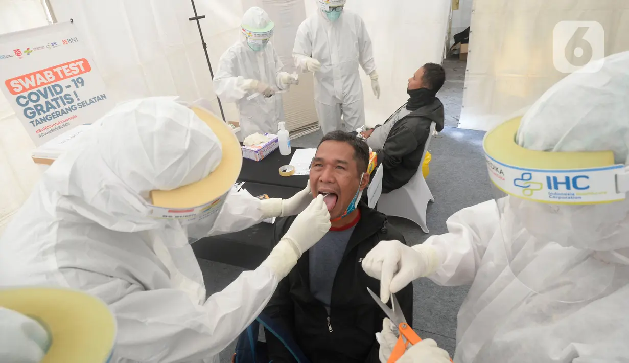 Petugas medis mengambil sempel lendir salah satu peserta test SWAB massal gratis di halaman Dinas Kesehatan Tangeramg Selatan, Banten, Minggu (30/8/2020). Test Swab gratis tersebut diikuti 750 orang untuk pencegahaan penyebaran Covid-19. (merdeka.com/Dwi Narwoko)