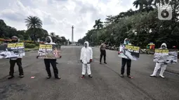 Aktivis membawa poster saat aksi "Sampah Impor Bunuh Sungai Pulau Jawa" di kawasan Patung Kuda, Monas, Jakarta, Senin (3/5/2021). Aktivis mendesak pemerintah menindak pabrik kertas impor dan tekstil sekitar Sungai Brantas, Bengawan Solo, Citarum, dan Ciujung. (merdeka.com/Iqbal S. Nugroho)