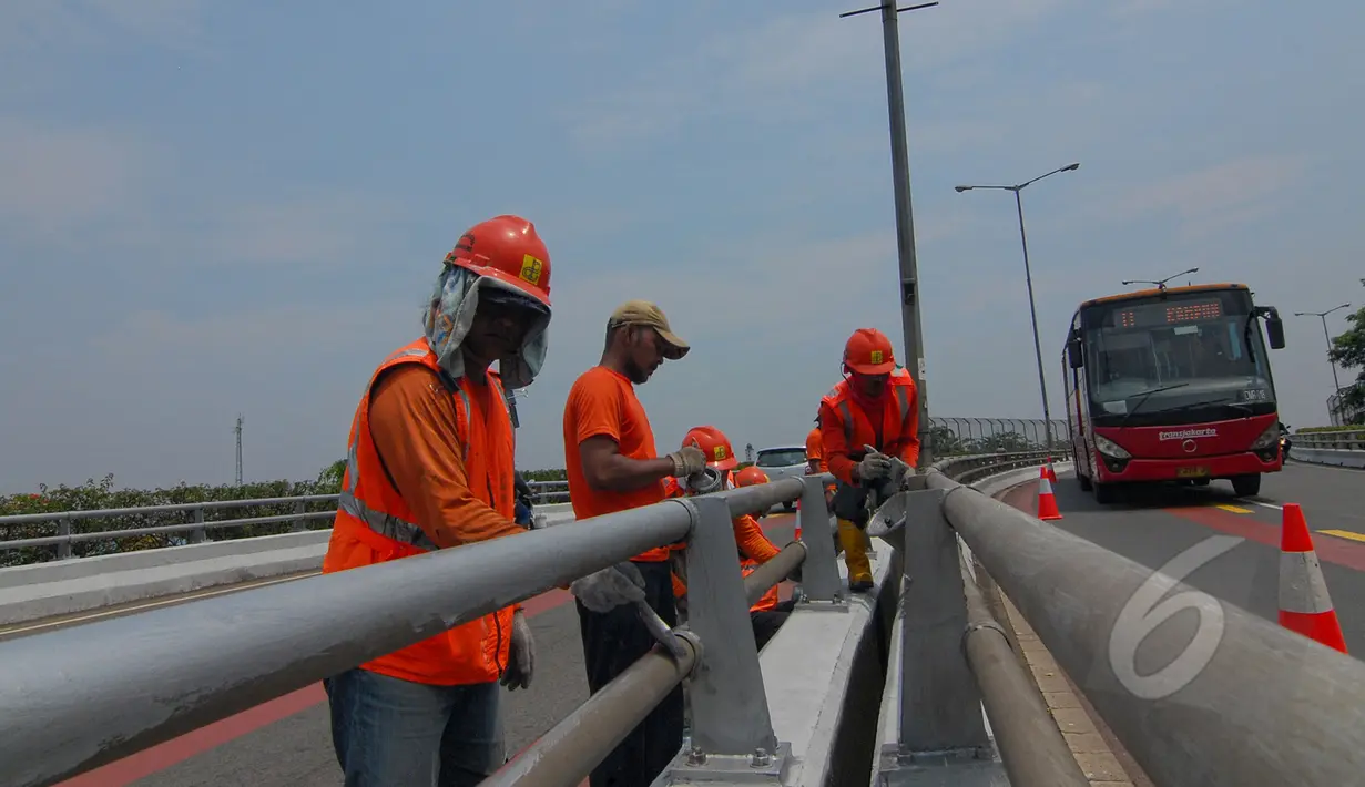 Sejumlah petugas Suku Dinas Pekerjaan Umum  melakukan peremajaan dengan melakukan pengecatan besi pembatas Fly Over di kawasan Cakung, Jakarta,  Rabu (1/4/2015). Panjang pembatas mencapai 120 meter (Liputan6.com/Yoppy Renato)