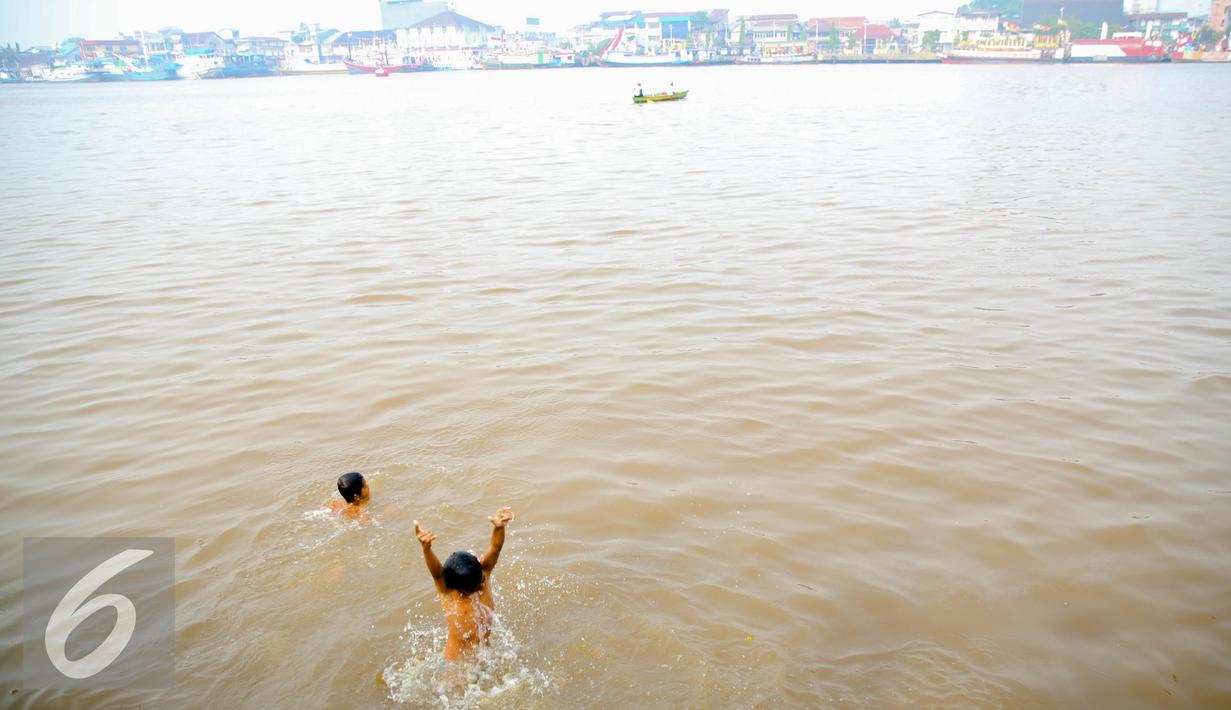 Sejumlah anak – anak tampak ceria saat berenang di Sungai Kapuas, Pontianak, Kalimantan Barat, Sabtu (22/8/2015). Sungai Kapuas Berhulu di Gunung Lawit, Kabupaten Kapuas Hulu, dan bermuara di Desa Jungkat, Kabupaten Pontianak. (Liputan6.com/Faizal Fanani)