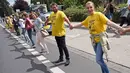 Demonstran membentuk rantai manusia untuk menuntut penutupan reaktor nuklir Belgia yang sudah menua di Aachen, Jerman barat, 25 Juni 2017. Aksi rantai manusia ini melintasi wilayah tiga negara, Jerman, Belgia dan Belanda. (Henning Kaiser / dpa / AFP)