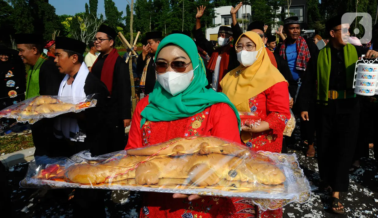 Warga membawa roti buaya saat pawai pada acara Lebaran Depok 2022 di Perumahan Shila Sawangan, Depok, Minggu (5/6/20222). Festival kebudayaan Lebaran Depok yang berlangsung 3 hari menampilkan berbagai  kegiatan pengenalan dan pelestarian budaya Kota Depok. (merdeka.com/Arie Basuki)