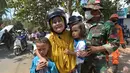Anggota TNI mengavakuasi seorang wanita beserta kedua orang anak saat terjadi gempa susulan di Tanjung pulau Lombok, NTB, Kamis (9/8).Gempa susulan terjadi kembali dengan kekuatan 6,2 skala richter dikawasan tersebut.(AFP/ ADEK BERRY)