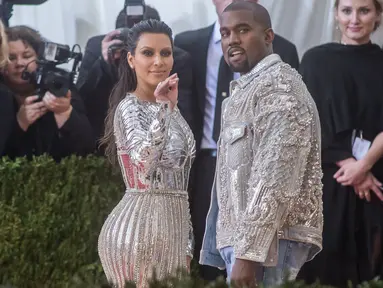 Pasangan Kanye West dan Kim Kardashian mencuri perhatian saat menghadiri ajang Met Gala 2016 di Metropolitan Museum of Art, New York City, Senin (2/5). Keduanya tampil senada mengenakan warna metalik perak. (Mark Sagliocco /Getty Images/AFP)