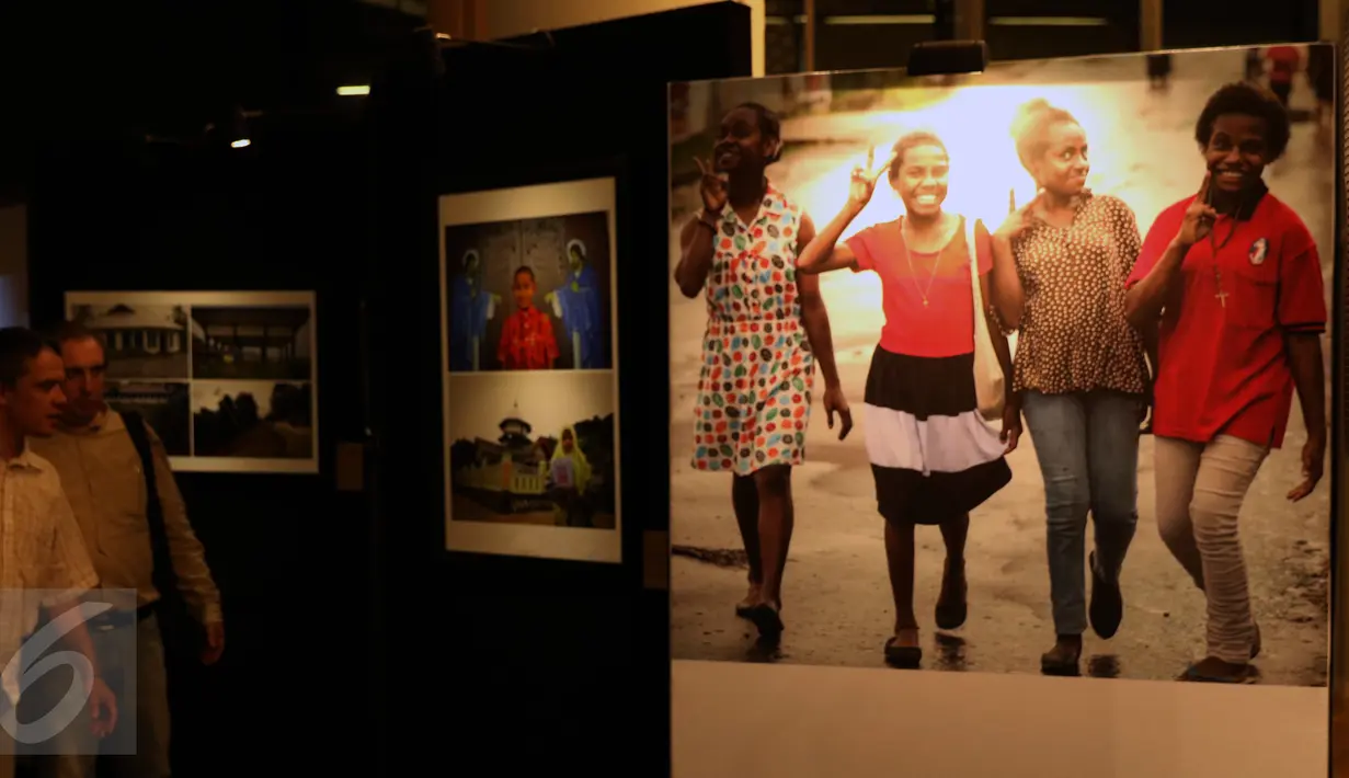 Pengunjung mengamati karya foto pada Pameran Papuaku Papuamu di Kuningan City, Jakarta, Selasa (27/12). Sebanyak 117 karya para pewarta foto ditamplkan dalam 40 bingkai. (Liputan6.com/Helmi Fithriansyah)