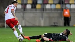 Pemain Kroasia Josip Juranovic (kiri) coba dihentikan pemain Malta Ryan Camenzuli pada pertandingan Grup H kualifikasi Piala Dunia 2022 di Stadion Rujevica, Rijeka, Kroasia, Selasa (30/3/2021). (Denis LOVROVIC/AFP)