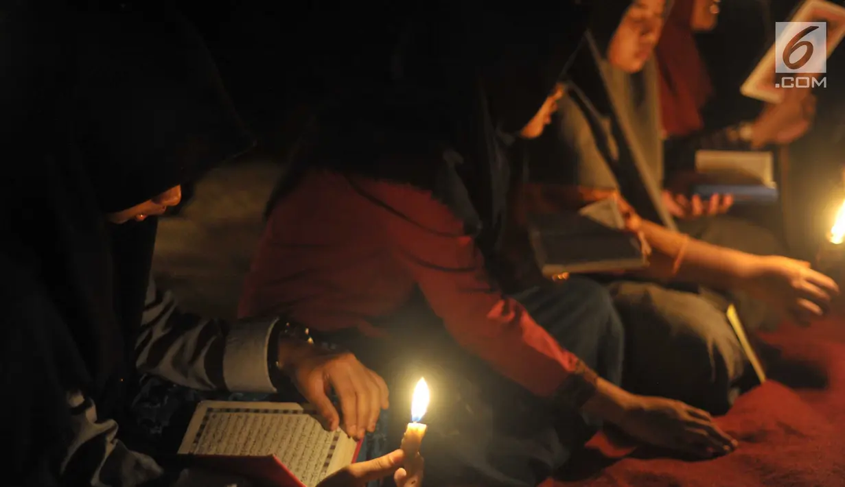 Santri dari Pondok Pesantren  Nurul Hidayah melakukan tadarus alquran dengan penerangan obor di tengah sawah Dusun Tempel, Desa Sempu, Kecamatan Andong, Kabupaten Boyolali, Selasa ( 21/5/2019). Pengajian tersebut untuk menyambut malam Nuzulul Quran pada 17 Ramadan 1440 Hijriah. (Liputan6.com/Gholib)