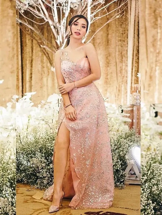 Pilihan tone warna peach dengan potongan sheath dan belahan samping pada gaun akan menambah anggun gayamu (Instagram/abellyc).