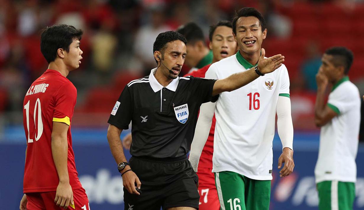 Wasit Khamis Mohamed Al Kuwari menunjuk titik penalti setelah tangan Hansamu Yama Pranata menyentuh bola tendangan Huy Toan Vo. (Bola.com/Arief Bagus)