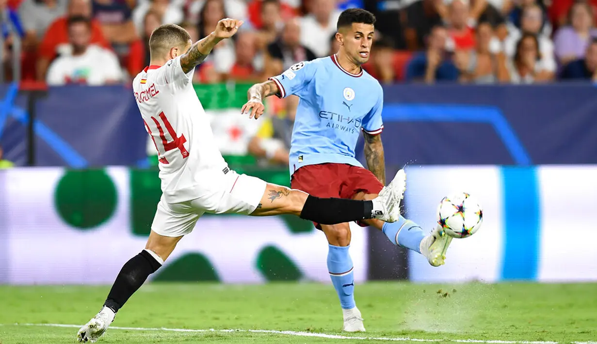 Pemain Manchester City Joao Cancelo berebut bola dengan pemain Sevilla Papu Gomez pada pertandingan sepak bola grup G Liga Champions di Seville, Spanyol, 6 September 2022. Manchester City menang 4-0. (AP Photo/Jose Breton)