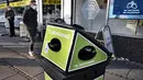 Pejalan kaki berjalan melewati tempat sampah untuk masker sekali pakai, di Aarhus Center, Denmark, Senin (23/11/2020). Kota Aarhus menempatkan seratus tempat sampah khusu berukuran 240 liter yang dapat menampung sekitar 3000 masker bekas. (Henning Bagger/Ritzau Scanpix/AFP)