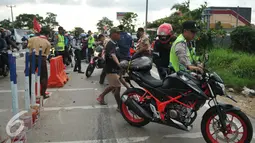 Petugas mencoba membantu menuntun motor akibat Kecelakaan yang terjadi di  jalan Lamaran, Karawang, Jawa Barat, Minggu (3/7). Kecelakaan kecil terjadi menimpa pemudik yang menggunakan sepeda motor di jalan Lamaran, Karawang. (Liputan6.com/Gempur M Surya)