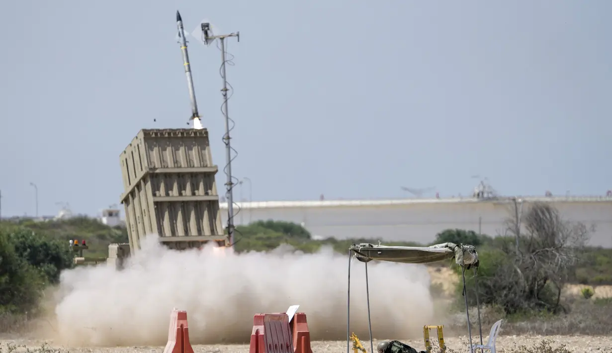 Seorang tentara Israel berlindung saat sistem pertahanan udara Iron Dome diluncurkan untuk mencegat roket yang ditembakkan dari Jalur Gaza di Ashkelon, Israel, 7 Agustus 2022. Militan Palestina telah meluncurkan hampir 600 roket ke Israel. (AP Photo/Ariel Schalit)