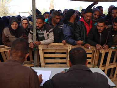 Warga Palestina menunggu giliran untuk menerima sekarung tepung bahan pangan di pusat distribusi di kota Khan Yunis, Jalur Gaza selatan, pada 3 Desember 2024. (BASHAR TALEB/AFP)