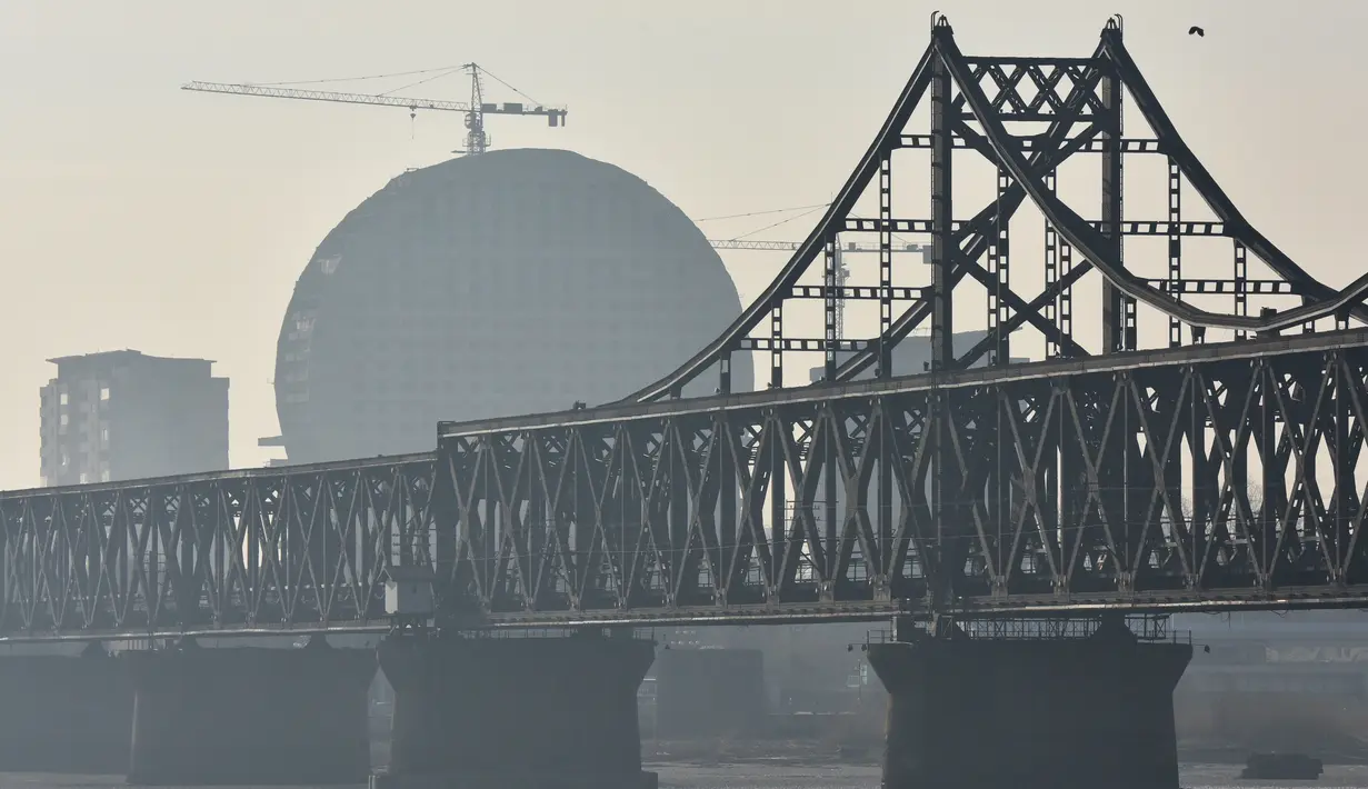 Suasana Jembatan Persahabatan yang membentang Sungai Yalu antara China dan Korea Utara terlihat dari kota Dandong di provinsi Liaoning, China (22/2). Pejalan kaki tidak diizinkan untuk menyeberangi Jembatan Persahabatan ini. (AFP Photo/Greg Baker)