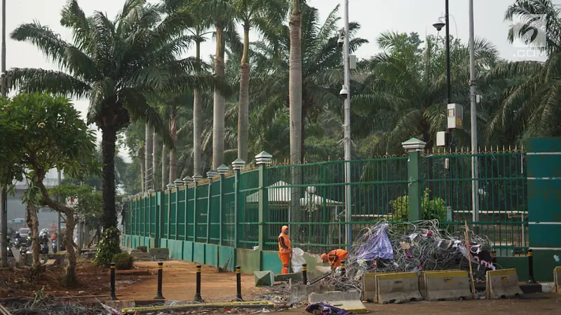 Petugas Bersihkan Sampah Sisa Bentrok