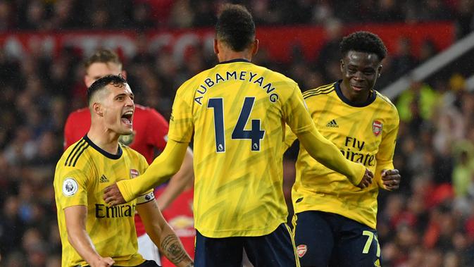Para pemain Arsenal merayakan gol yang dicetak Pierre-Emerick Aubameyang ke gawang Manchester United pada laga Premier League di Stadion Old Trafford, Manchester, Senin (30/9). Kedua klub bermain imbang 1-1. (AFP/Paul Ellis)