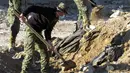 Polisi Irak menggali sebuah kuburan massal yang diduga berisi puluhan jenazah yang dieksekusi oleh kelompok ISIS di Kota Ramadi, sebelah barat Baghdad, Selasa (26/1). Kuburan massal tersebut berisi sisa-sisa sekitar 40 jasad. (AFP/ MOADH AL-DULAIMI)