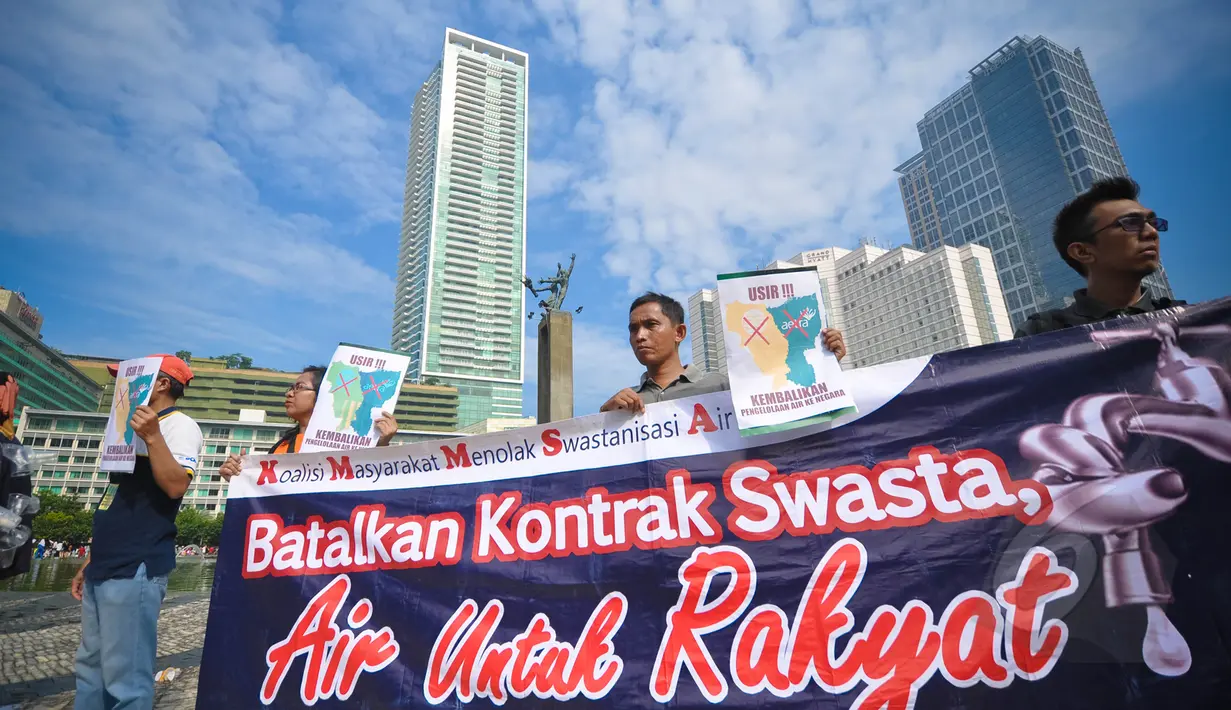 Aktivis Koalisi Masyarakat Menolak Swastanisasi Air Jakarta membentangkan spanduk saat menggelar aksi Menolak Swastanisasi Air Jakarta di Bundaran HI, Jakarta, Minggu (22/3/2015). (Liputan6.com/Faizal Fanani) 