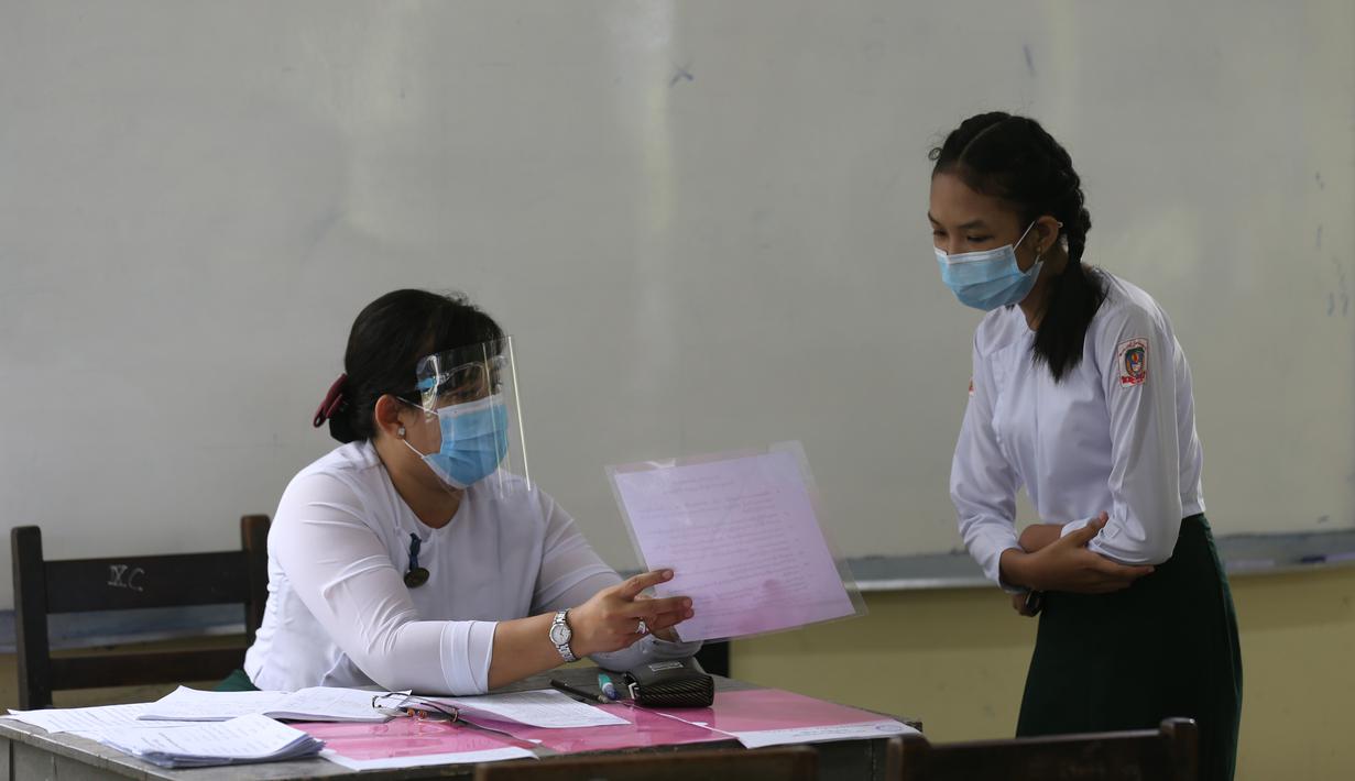 Seorang guru menjelaskan peraturan sekolah untuk mencegah penyebaran virus COVID-19 kepada siswa saat hari pendaftaran sekolah di Yangon, Myanmar (13/7/2020). Myanmar sejak Selasa (7/7) memulai pendaftaran sekolah untuk tahun ajaran 2020-2021, yang tertunda akibat pandemi COVID-19. (Xinhua/U Aung)