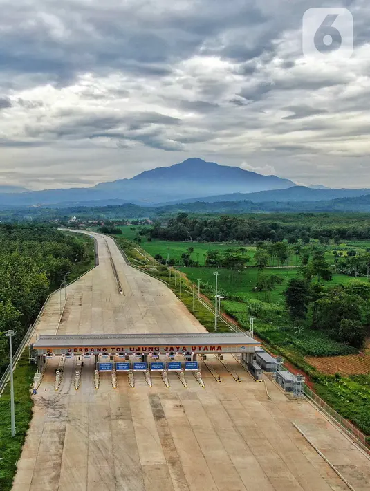 Foto udara pembangunan Gerbang Tol Ujung Jaya Utama bagian dari Tol Cileunyi-Sumedang-Dawuan (Cisumdawu) seksi enam di Kabupaten Majalengka, Jawa Barat, Rabu (28/12/2022). Kementerian Koordinator Bidang Perekonomian melalui KPPIP meninjau progress dan optimalisasi untuk akses jalan tol menuju Bandara Kertajati dan solusi antisipasi kemacetan jalan nasional Bandung ke Majalengka serta target fungsional secara keseluruhan di kwartal satu 2023 dalam mendukung arus mudik lebaran. (Liputan6.com/Angga Yuniar)