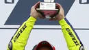 Pembalap Yamaha, Valentino Rossi saat mengangkat piala kemenangan setelah menjadi yang terdepan di Moto Gp seri ke-12 di sirkuit Silverstone (30/8/2015). Posisi kedua dan ketiga diduduki Danilo Petrucci dan  Andrea Dovizioso. (REUTERS/Darren Staples)