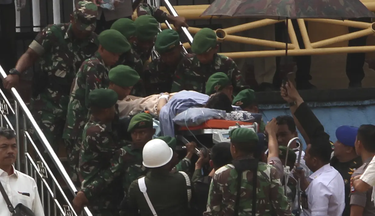Personel TNI dan polisi membawa Menko Polhukam Wiranto menuju helikopter usai diserang orang tak dikenal di Pandeglang, Banten, Kamis (10/10/2019). Wiranto yang mengalami luka tusuk di bagian perut akibat penyerangan itu dibawa ke RSPAD Gatot Subroto, Jakarta dengan helikopter. (AP Photo/Rafsanjani)