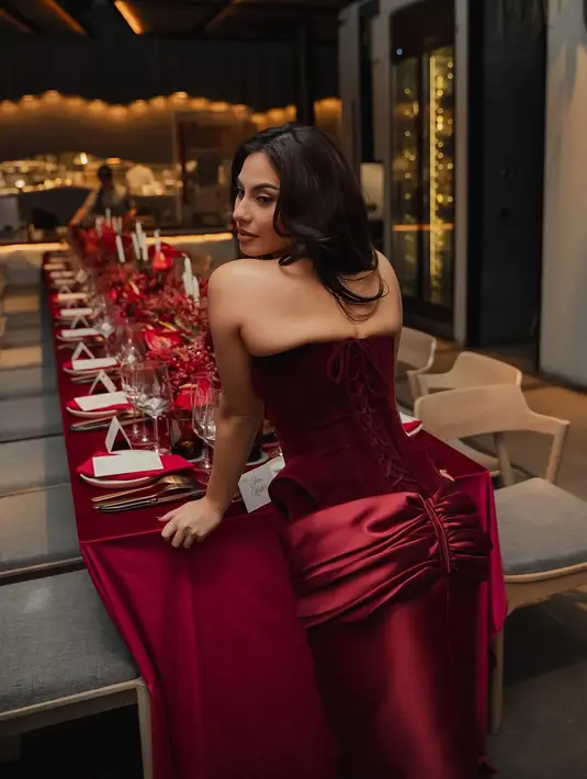 Dipadu dengan rok merah satin berdetail kerut di bagian pinggang yang bikin terlihat makin anggun [@valerieethomas]