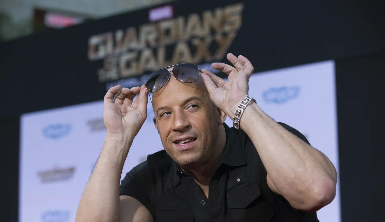 Pria berkepala plontos itu bergaya dengan mengangkat kecamatanya saat berpose di red carpet acara premiere "Guardians Of The Galaxy" di Hollywood, California, Selasa (22/7/14). (REUTERS/Mario Anzuoni)