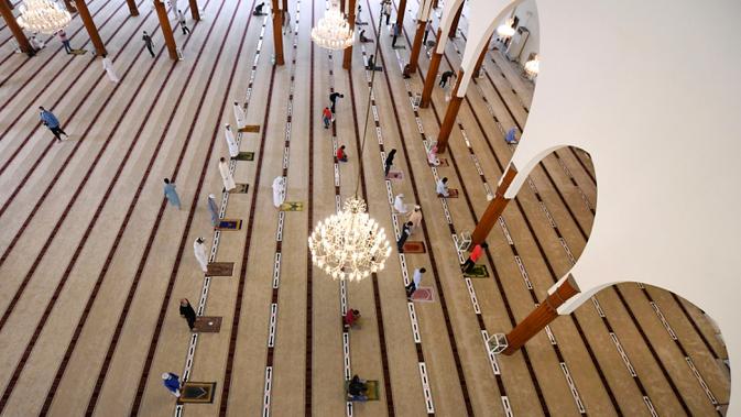 Jemaah menjaga jarak ketika salat di sebuah masjid di Sharjah setelah Uni Emirat Arab membuka kembali tempat-tempat ibadah pada Rabu (1/7/2020). Sebelumnya UEA menghentikan sementara salat berjemaah di masjid-masjid dan tempat ibadah lainnya untuk menghentikan penyebaran Covid-19. (KARIM SAHIB/AFP)