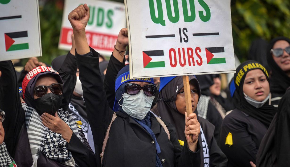 Dalam aksinya, massa juga menyerukan kepada dunia internasional untuk segera menghentikan konflik dan kekerasan yang terjadi di kawasan Timur Tengah. Tampak dalam foto, para perempuan memegang plakat dan meneriakkan slogan-slogan selama berunjuk rasa memperingati Hari Al-Quds, di Surabaya, Jawa Timur, Jumat (13/3/2026). (Juni KRISWANTO/AFP)