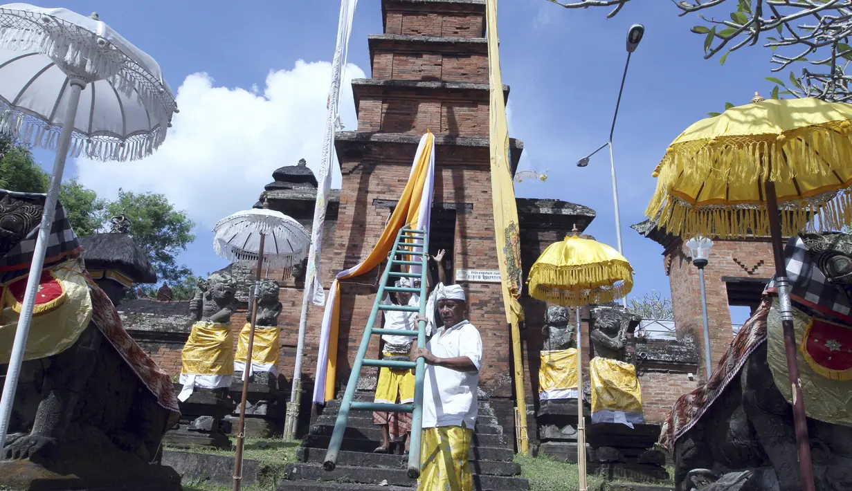 Warga Bali mendekorasi pintu masuk sebuah kuil Hindu di dekat lokasi yang akan dikembangkan menjadi resor bintang enam yang dikelola oleh Trump Organization di Beraban, Bali, Rabu (12 /4). (AP Photo)