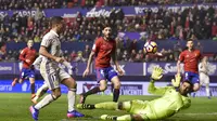 Pemain Real Madrid, Lucas Vazquez (kiri) mencetak gol ke gawang Osasuna dengan mengecoh kiper, Salvatore Sirigu pada lanjutan La Liga di El Sadar stadium, Pamplona, (11/2/2017).  Real Madrdi menang 3-1. (AP/Alvaro Barrientos)
