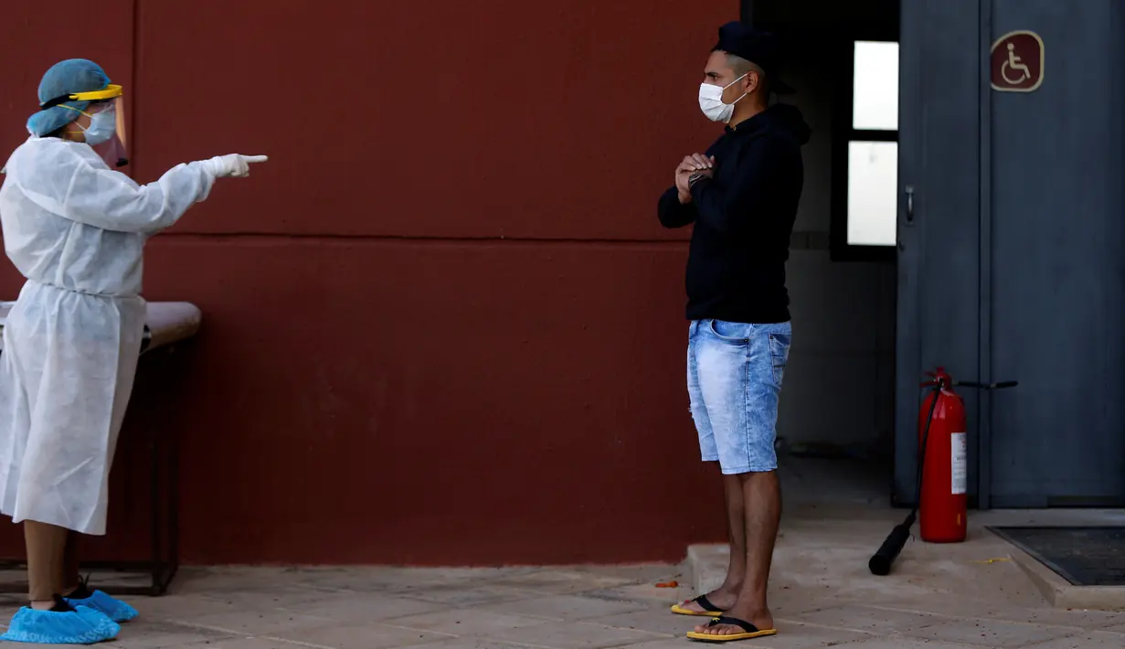 Petugas mewawancara pemuda yang menjalani karantina di fasilitas olahraga Ciudad del Este, Paraguay, Rabu (24/6/2020). Ada 15 ribu warga Paraguay masih menunggu untuk masuk kembali ke negara itu di negara-negara tetangga seperti Brasil dan Argentina. (AP Photo/Jorge Saenz)