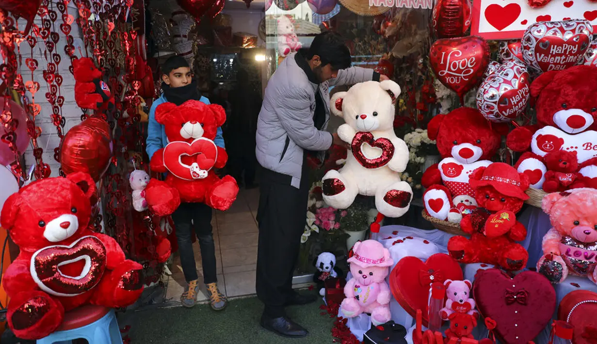 Pemilik toko mengatur boneka beruang saat menunggu pelanggan di toko suvenir pada Hari Valentine di Kabul, Afghanistan, Minggu (14/2/2021). Hari Valentine menjadi budaya baru dalam masyarakat Afghanistan yang konservatif. (AP Photo/Rahmat Gul)