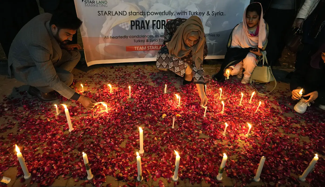 Para peserta menyalakan lilin saat menyalakan lilin untuk para korban gempa bumi di Suriah dan Turki, di Islamabad, Pakistan, Senin, 6 Februari 2023. Gempa Turki dan Suriah merobohkan ratusan bangunan dan menewaskan ribuan orang serta diyakini ratusan lainnya masih terperangkap di bawah puing-puing. (AP Photo/Anjum Naveed)
