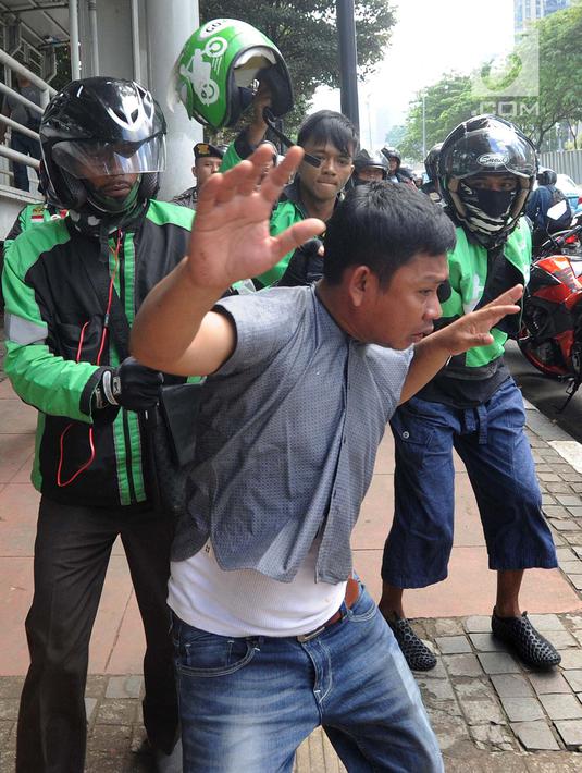 Pengemudi ojek online mengamankan terduga copet untuk diamankan ke Mapolda Metro Jaya di Jalan Jenderal Sudirman, Jakarta (2/4). (Merdeka.com/Arie Basuki)