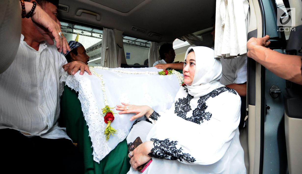 Istri alm RMH Heroe Siswanto NS atau dikenal Sys NS, Shanty Widhiyanti di sisi jenazah saat dibawa dari rumah duka, Jakarta, Selasa (23/1). Sys NS wafat diusia 61 tahun akibat serangan jantung. (Liputan6.com/Helmi Fithriansyah)