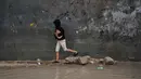 Situasi ini meningkatkan risiko penyebaran penyakit menular, terutama bagi anak-anak dan lanjut usia (lansia). Tampak dalam foto, seorang anak pengungsi Palestina berjalan melewati kamp tenda yang basah kuyup setelah hujan lebat di Deir al-Balah, Jalur Gaza tengah, Kamis, 26 Maret 2026. (AP Photo/Abdel Kareem Hana)